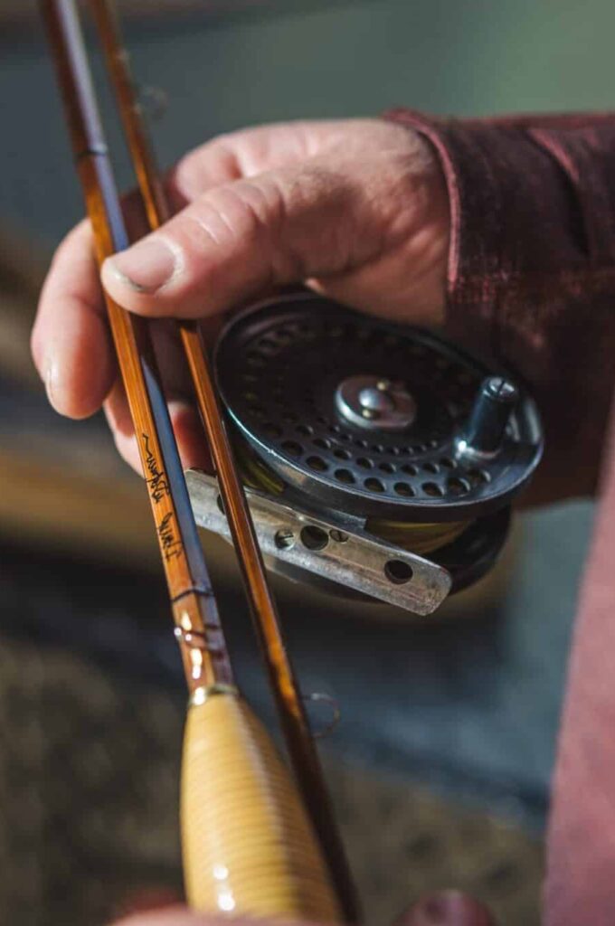 Holding a handcrafted bamboo fly rod.