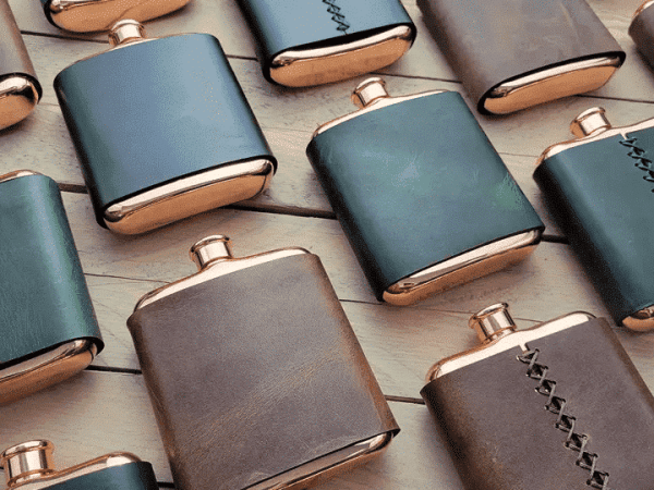 Copper wrapped in leather flask with twist on lid.