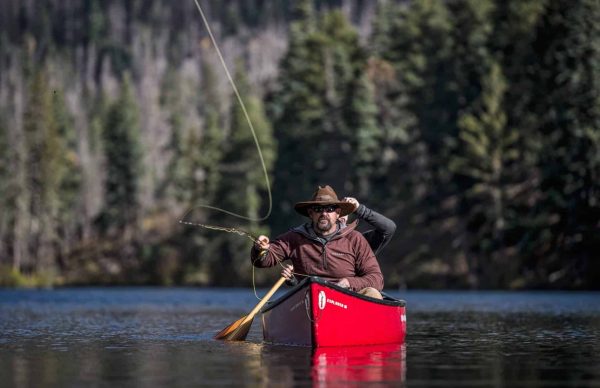 Fly fishing in a canoe on a lake.